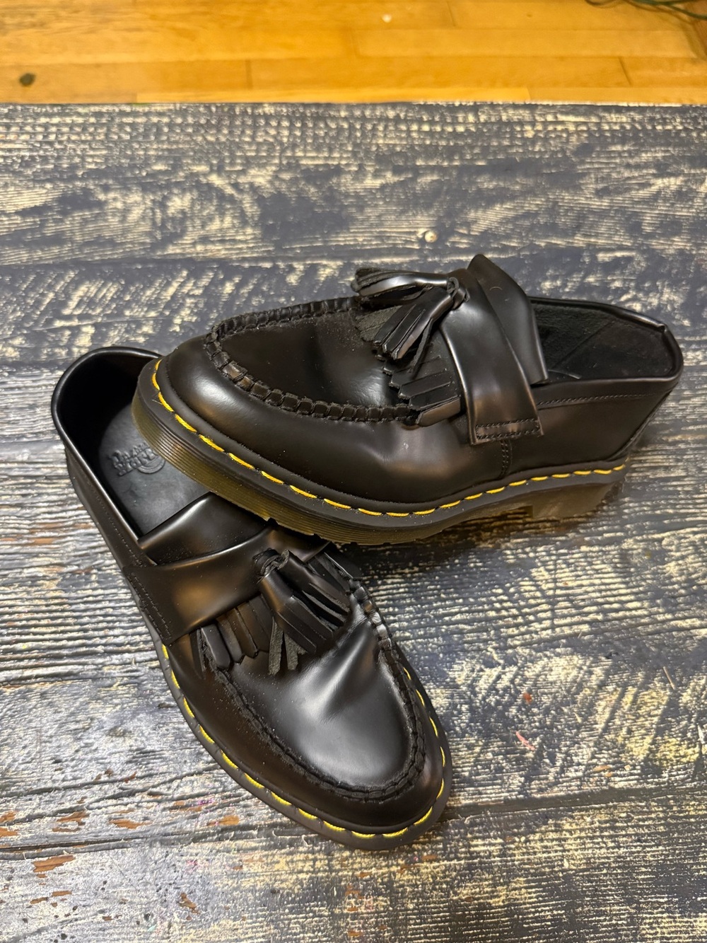 Dr. Martens “Adrian” Black Tassel Leather Mule Loafer with Yellow Stitching.